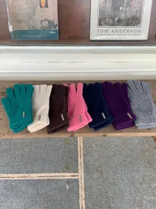 Makroaufnahme von Strickhandschuhen in verschiedenen Farben mit Metallelementen.