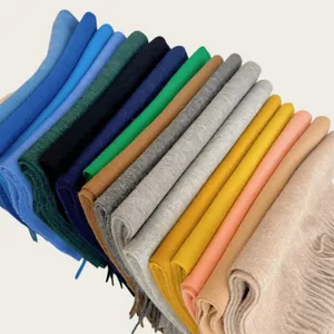 Stacked 100% wool scarves in various colors showing soft texture and fringe details