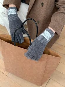 Gros plan sur des gants en tricot de lana gris rétro avec étiquette de marque blanche
