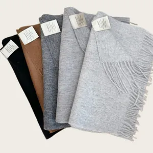 Detailed view of 100% Australian wool scarves in five neutral colors with labels