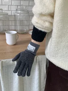 Détail de gants en laine tricotée grise rétro dans un décor de cuisine chaleureux