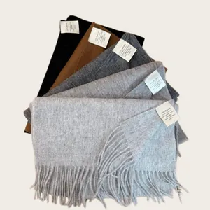 Detail of stacked 100% Australian wool scarves in various neutral colors with content labels