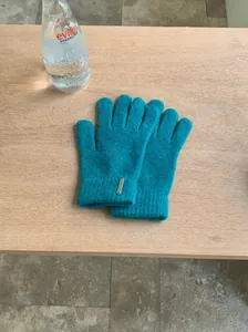 Petrolfarbene Strickhandschuhe aus Wollmischung mit kleinem Metallelement auf Holzfläche