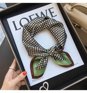Close-up of a stylish geometric silk-like square scarf for women's fashion.