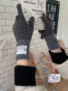 Gants en laine tricotée gris foncé confortables pour femmes avec étiquette rétro et longs poignets
