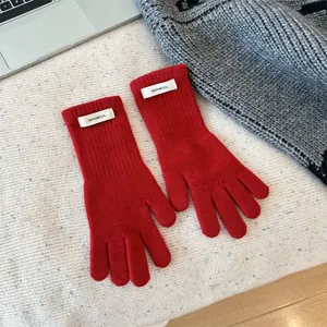 Detailed view of vibrant red 100% wool knit winter gloves featuring rib-knit cuffs