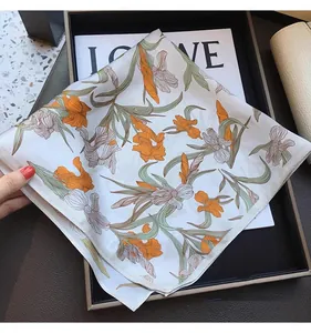 Detailed view of elegant floral silk-like square scarf in high-end tray setting