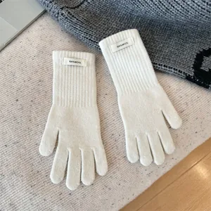 Detailed view of white 100% merino wool knitted gloves with very soft texture