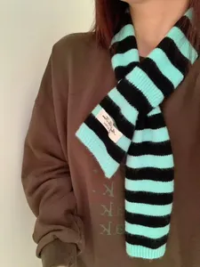 Detail shot of turquoise and black striped wool blend scarf with keyhole design.