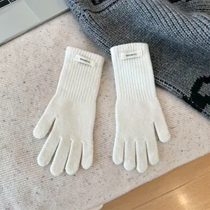 Detail view of 100% wool merino winter gloves showing soft knit texture and brand label