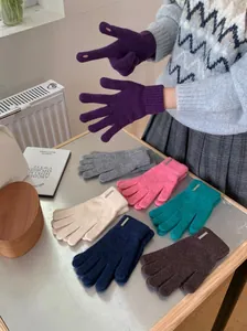 Detailansicht verschiedener Wollstrickhandschuhe mit Touchscreen-Fingeröffnungen