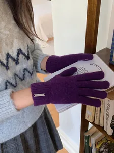 Detailansicht der lila gestrickten Winterhandschuhe mit Metalldetail.