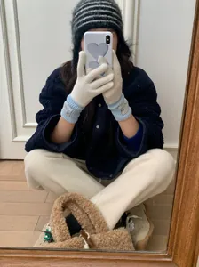 Gros plan de gants en laine tricotés de style coréen avec poignets bleu clair en selfie