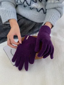 Detailansicht gemütlicher, lilafarbener Wollmisch-Strickhandschuhe mit elegantem Metallanhänger