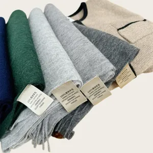 Close-up of 100% Australian wool scarf labels showing fabric content and fine texture detail