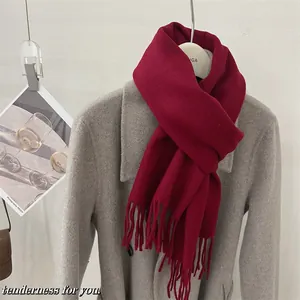 Écharpe élégante en laine d'Australie 100 % rouge vin avec franges sur un manteau gris