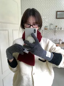 Détail de gants en laine tricotée gris avec étiquette blanche décorative femme