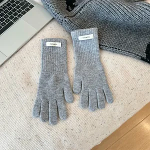 Close-up detail view of grey 100% Merino wool knitted gloves with premium wool label