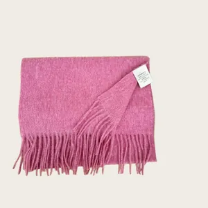 Detail of 100% Australian wool scarf in pink with soft tassel fringe and care label.