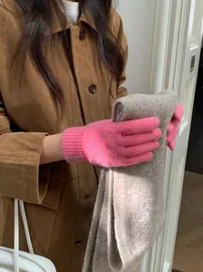 Detailansicht der leuchtend rosa gestrickten Wollhandschuhe für Damen im Winter-Design.