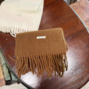 Detalle de la textura de bufandas gruesas de lana con flecos en mesa