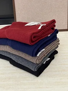 Detailed macro view of stacked 100% Australian wool knitted scarves in various colors