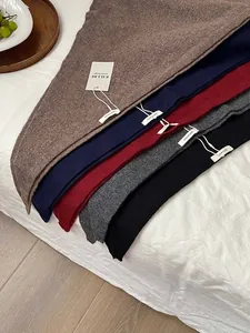 Detailed view of 100% wool knitted triangle shawls in various autumn colors.