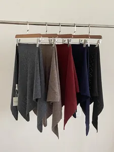 Selection of 100% wool knitted triangle shawls in five colors displayed on a rack
