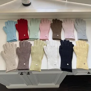 An assortment of thirteen colorful knitted wool gloves with soft ribbed texture for winter
