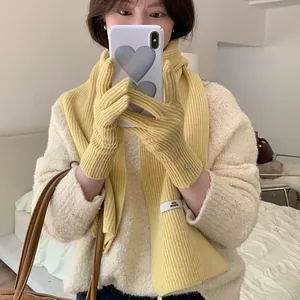 Detailed view of a soft yellow ribbed knitted scarf and matching gloves set for women