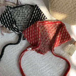 Detalle de bufandas triangulares de punto a rayas con lazos en fondo texturizado