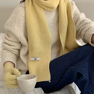 Macro view showing the soft texture of a yellow knitted scarf and matching gloves for winter