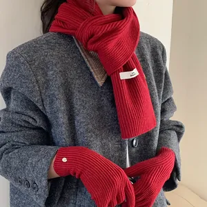 Detail shot of the soft red knitted texture on the scarf and gloves set for women
