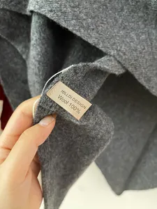 Detailed view showing the 100% Australian wool label and grey soft knitted fabric texture