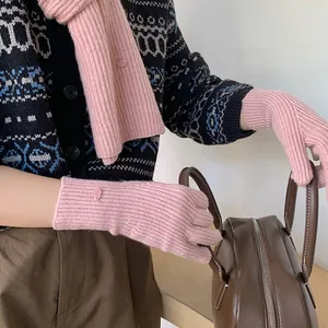 Close-up detail of soft pink knitted scarf and matching gloves for women in winter