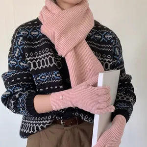 Close-up of elegant pink rib-knit scarf and gloves set with small metal logo detail