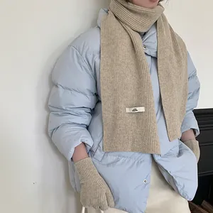 Detail of soft beige ribbed knit scarf and matching gloves set for winter warmth