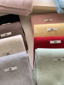 Detail view of multi-color ribbed knit scarves featuring pink Dolphin brand labels