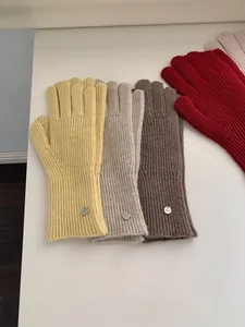 Detailed view of warm solid color knitted wool gloves in yellow, beige and brown