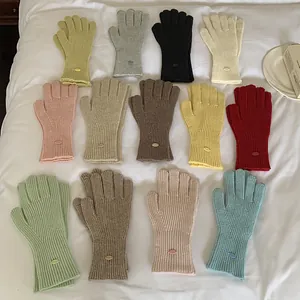 Collection of warm winter knitted gloves for women in multiple solid colors with metal tag.