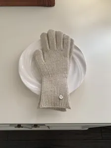 Elegant beige knitted wool gloves for women, soft minimalist winter warm accessories.