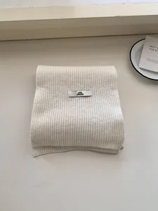 Soft cream white knitted ribbed scarf featuring a Pink Dolphin brand woven label tag