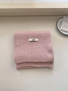 Elegant soft pink knitted winter scarf with ribbed texture and pink Dolphin logo tag