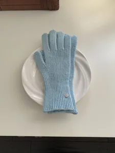 Elegant light blue ribbed knitted winter gloves with small silver decorative brand tag