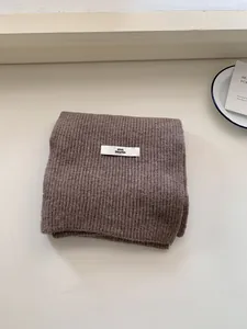 Premium soft brown ribbed knit wool scarf for winter with a minimalist brand label