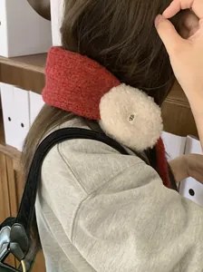 Rückansicht einer Frau mit roten gestrickten Ohrenschützern und weichem weißem Plüsch