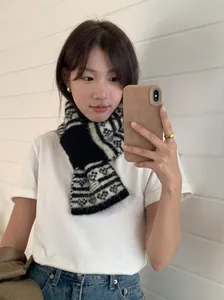 Vue détaillée d'une écharpe en maille rétro Fair Isle portée par un mannequin en situation.