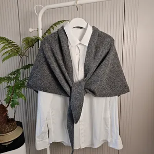 Elegante grijze gebreide wollen mix sjaal met pailletten gedrapeerd over een wit overhemd