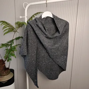Detailopname van de donkergrijze gebreide sjaal met lovertjes aan een hanger