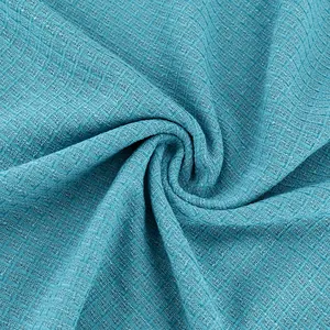Détail macro du tissu en tweed turquoise montrant la texture du tissage et du bouclé